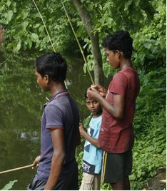 Mogra, West Bengal: Three young boys fishing in a pond. They were so happy when we brought a printed photo to their home.
