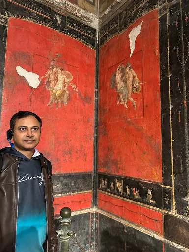 পম্পেইয়ের লাল মাসাইক ও মোজাইকের সামনে একজন পর্যটক